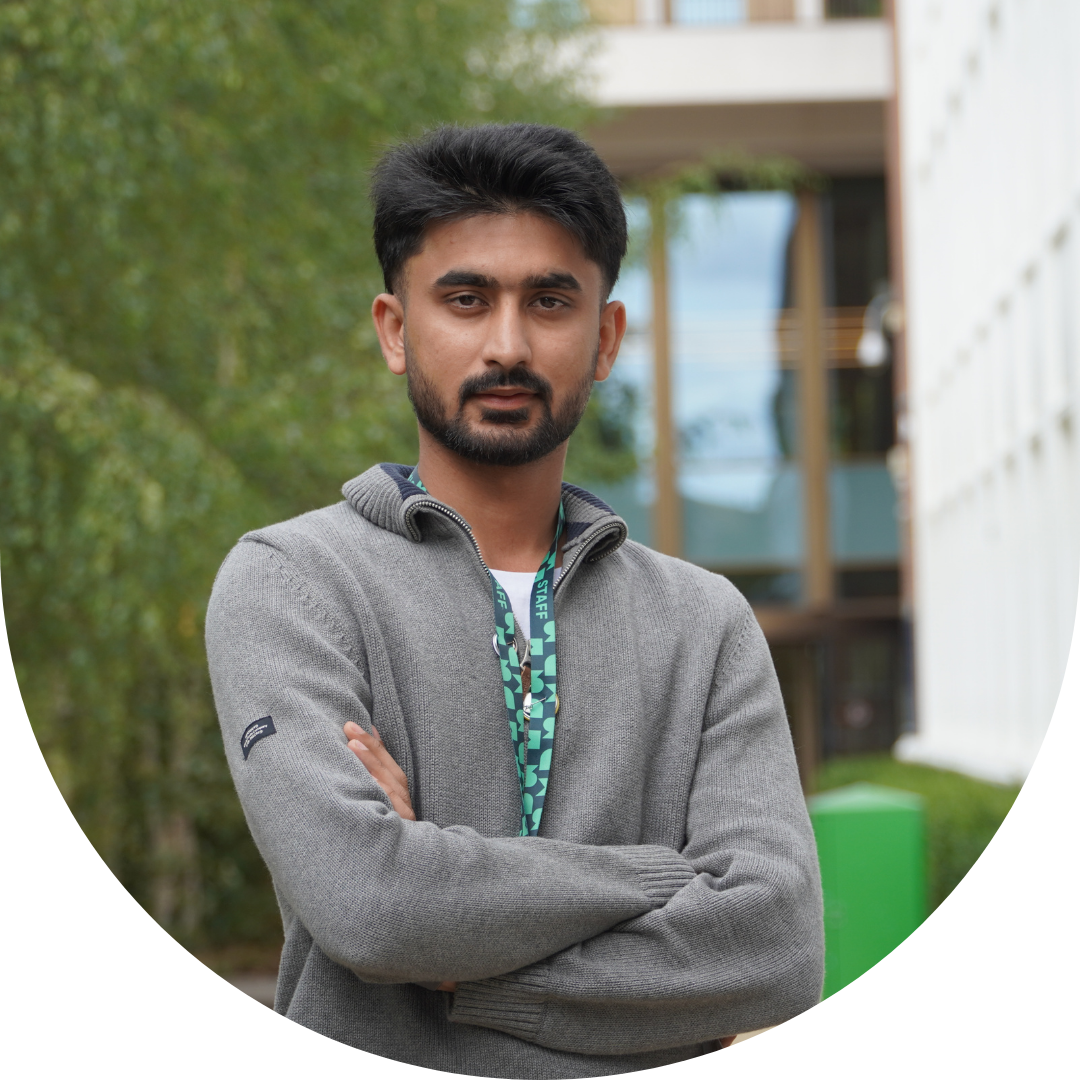 Person with beard and dark hair wearing a black jumper and shirt