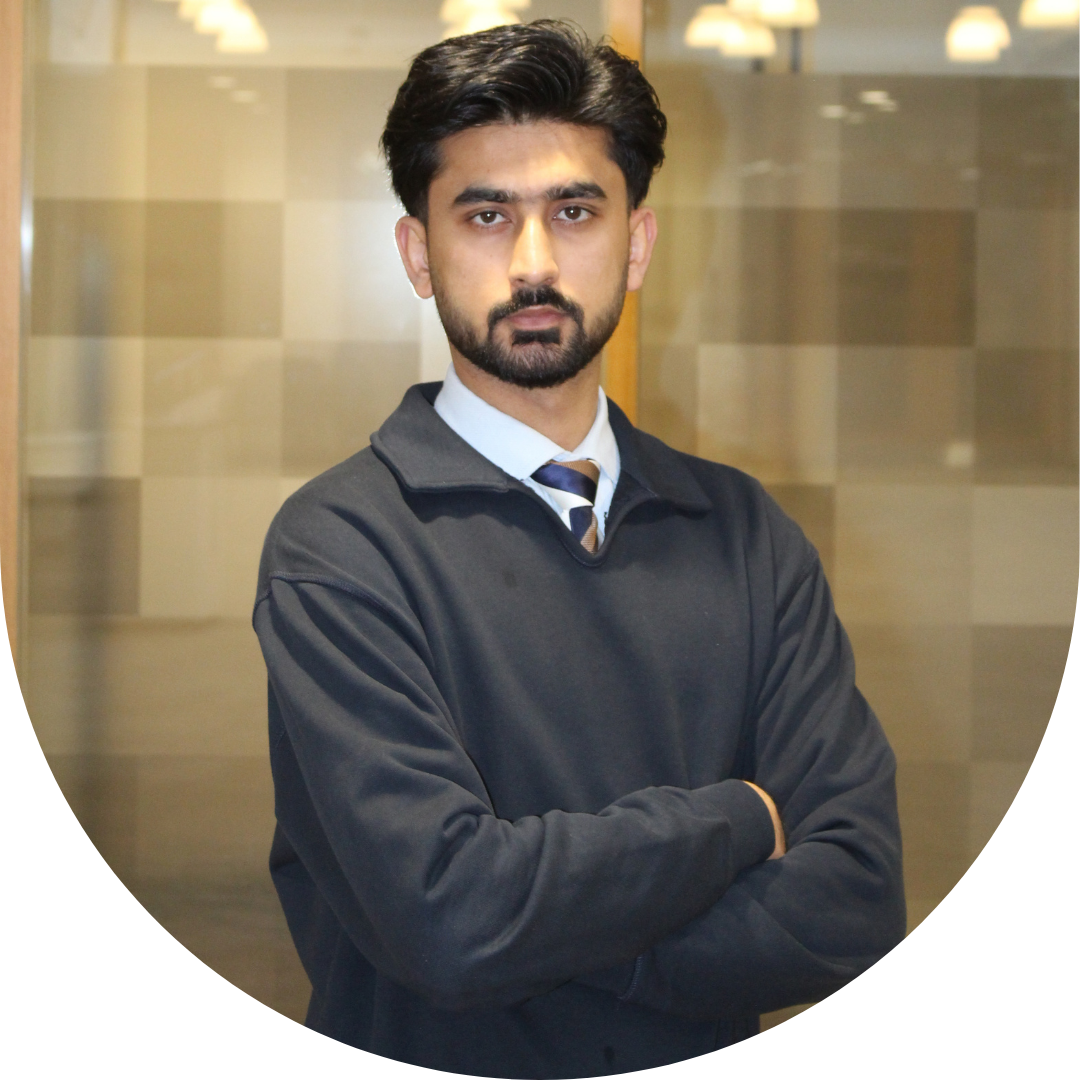 Person with beard and dark hair wearing a black jumper and shirt