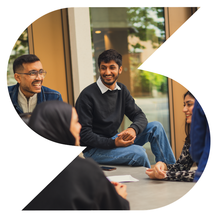 Group of people sat having a conversation in a university building